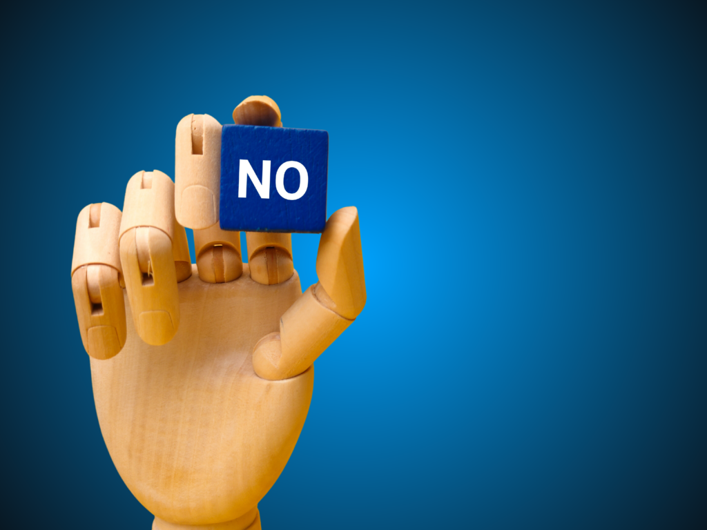 wooden hand holding blue cube with the word no essentialism professional