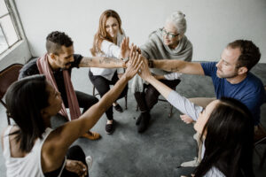 Group of diverse team joining hand in the middle for mental health