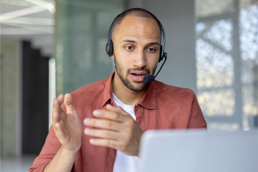 Young leader speaking into a video conference behind his laptop