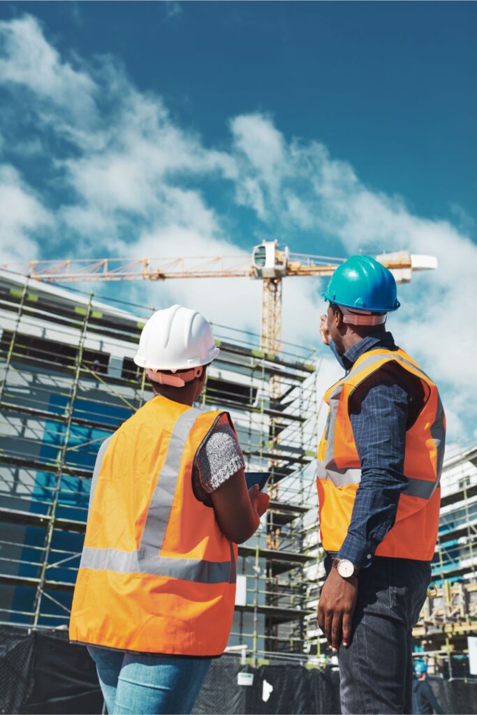 two construction executive leaders looking up toward the progress of their project with blue skies above it