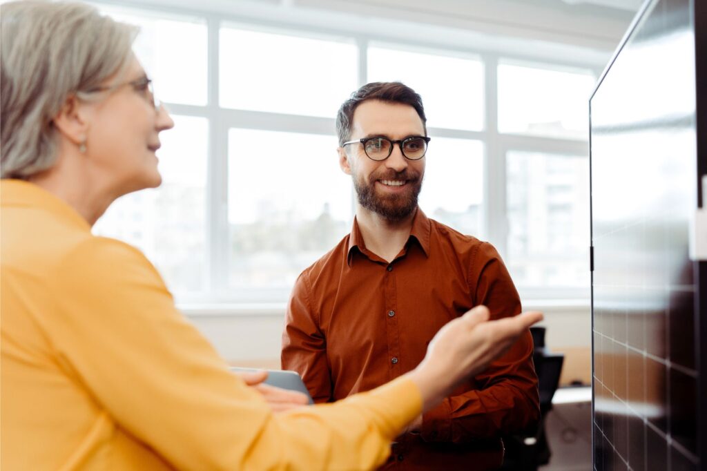Manager giving positive feedback pointing to employee's presentation preparation