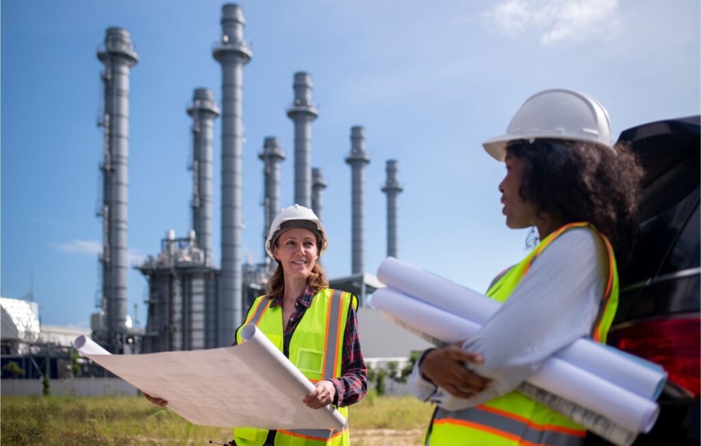 Woman energy leader reviewing engineering blueprints with employee