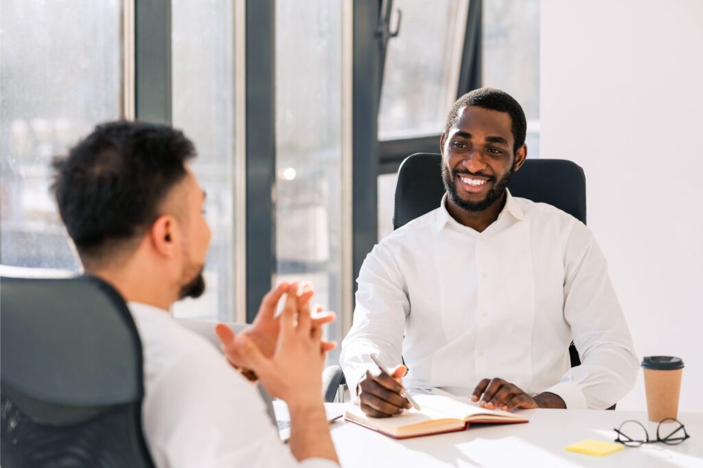 Young man receiving feedback well in conversation with colleague