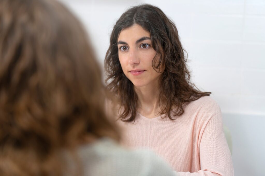 Brunette woman listening intently to female manager's feedback.